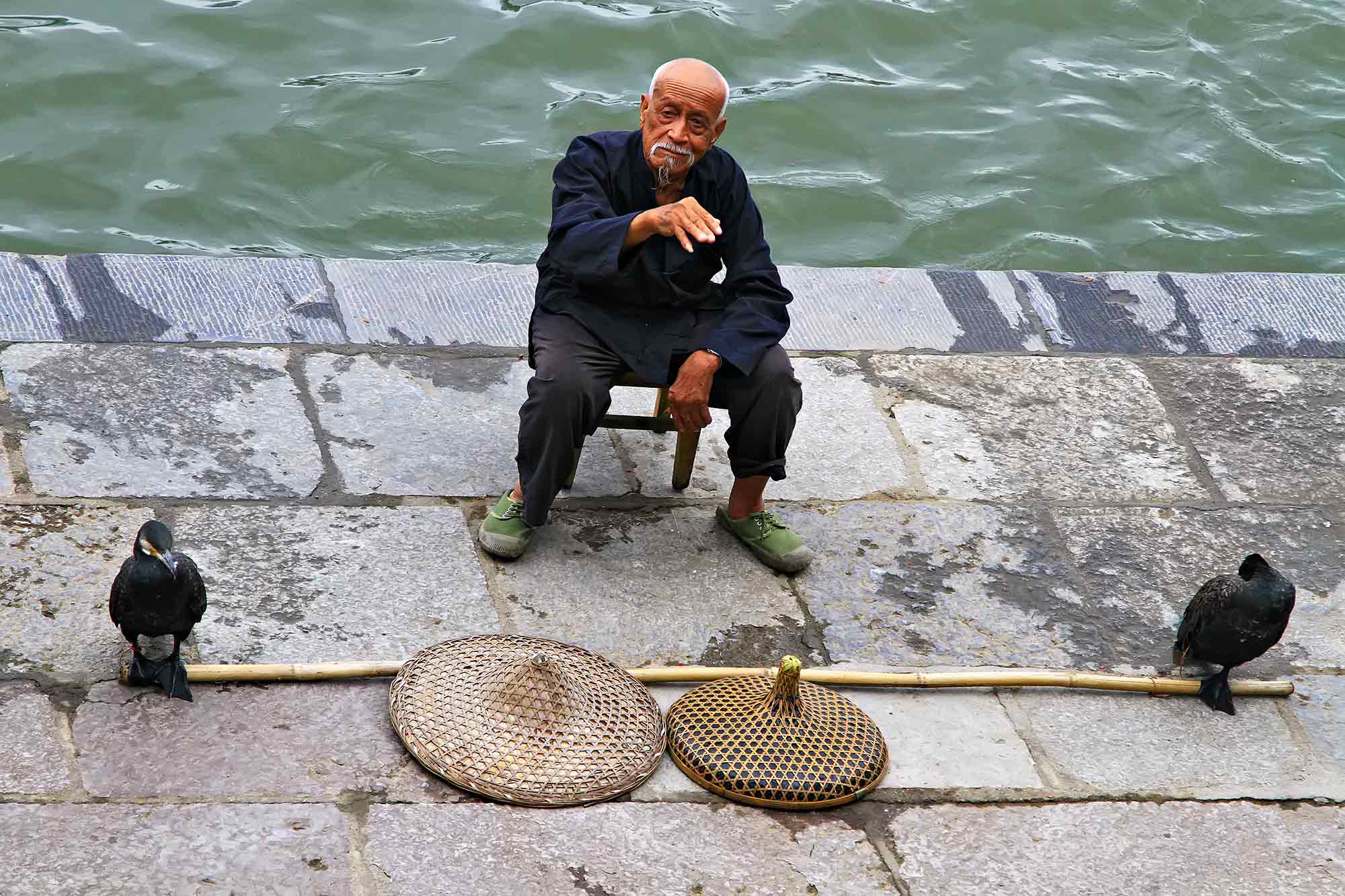 A fisherman and his Cormorants along the Li River in Yangshuo, China. © Ulli Maier & Nisa Maier