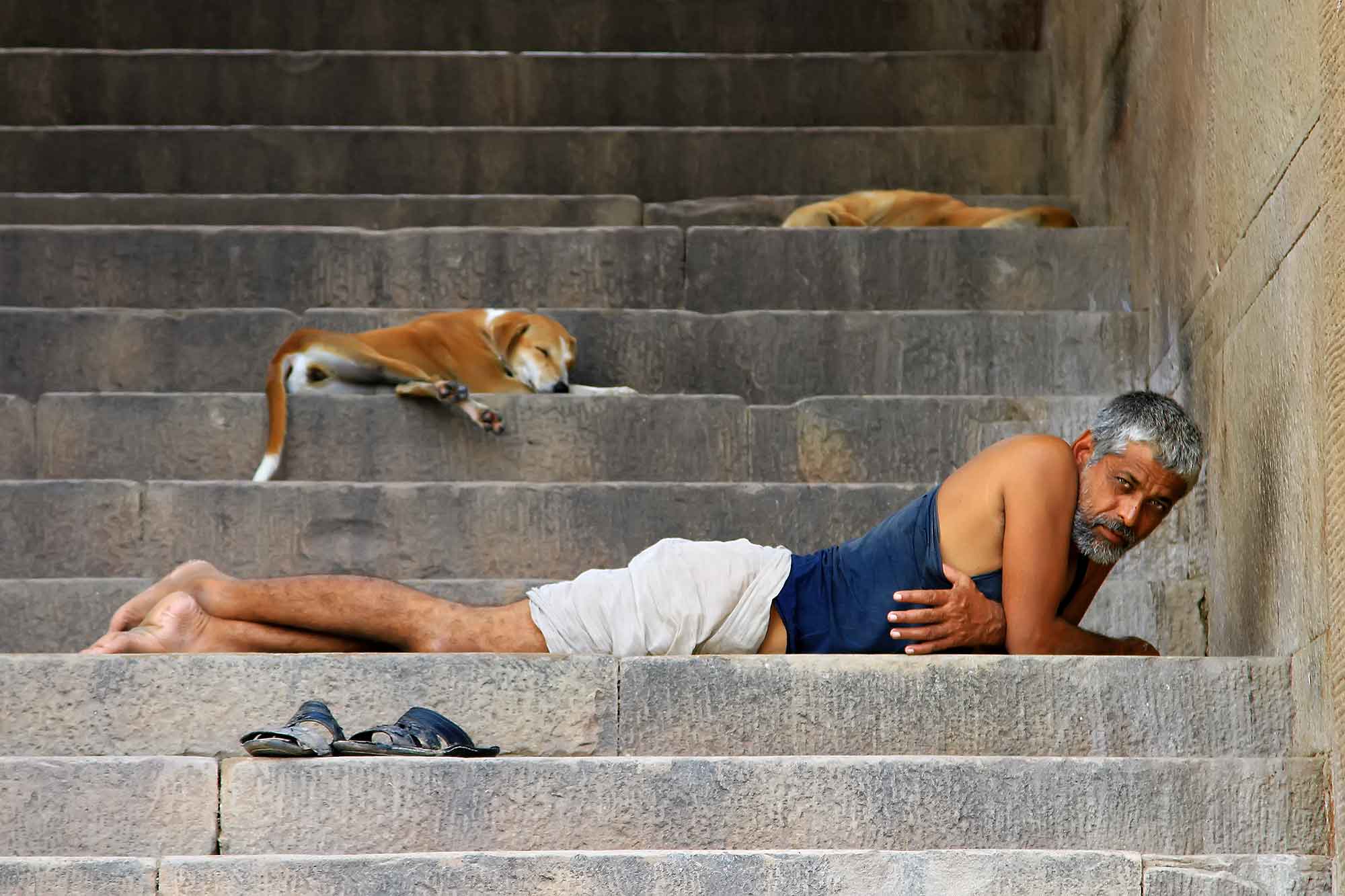 man-resting-stairs-ghats-varanasi-india